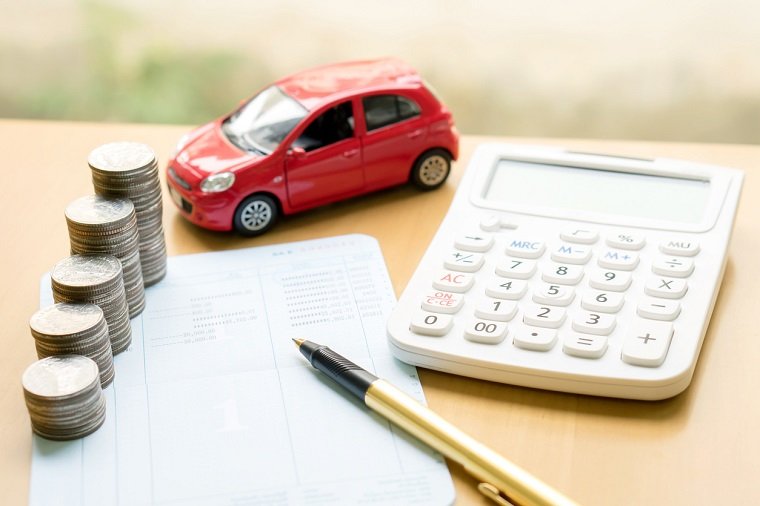 Rotes Spielzeugauto, gestapeltes Münzgeld und Taschenrechner