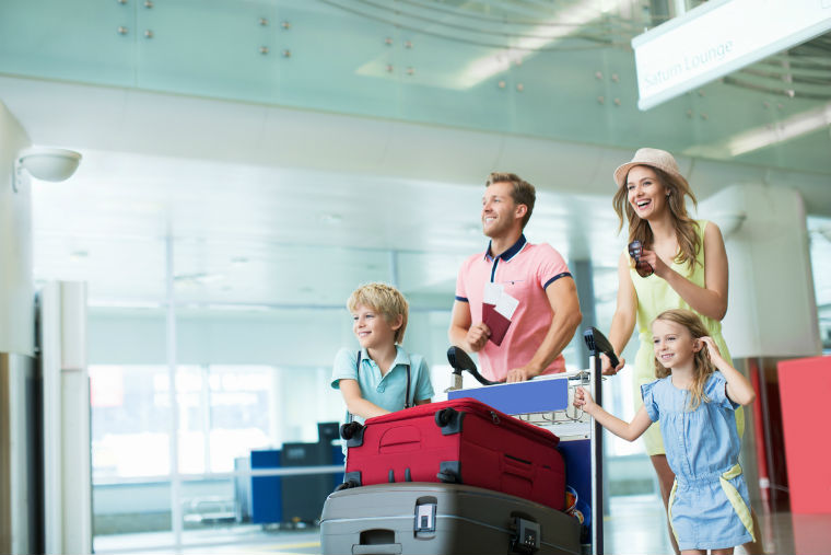 Familie am Flughafen mit Kofferwagen