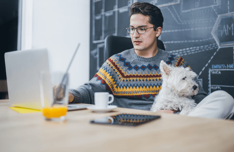 Mann mit Hund im Büro am Schreibtisch