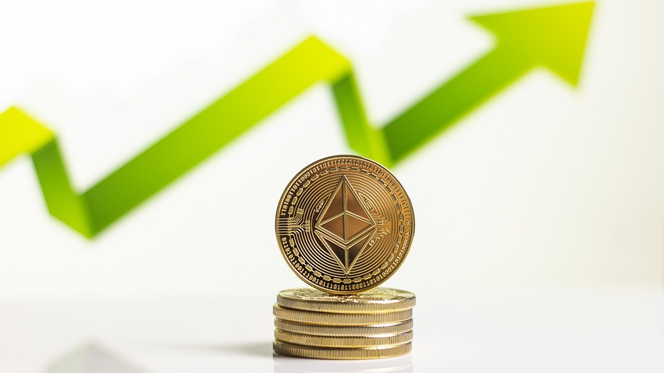 Bitcoins im Vordergrund, ein nach oben zeigender grüner Pfeil im Hintergrund