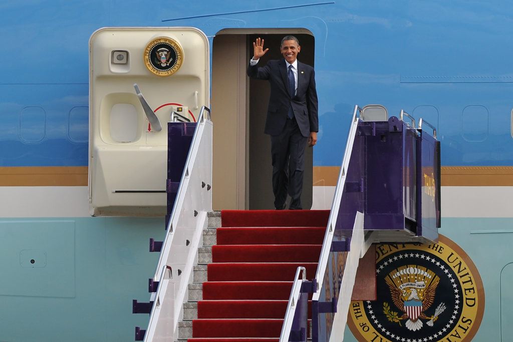 Obama steht im Eingang des Flugzeuges der vereinigten Staaten und winkt