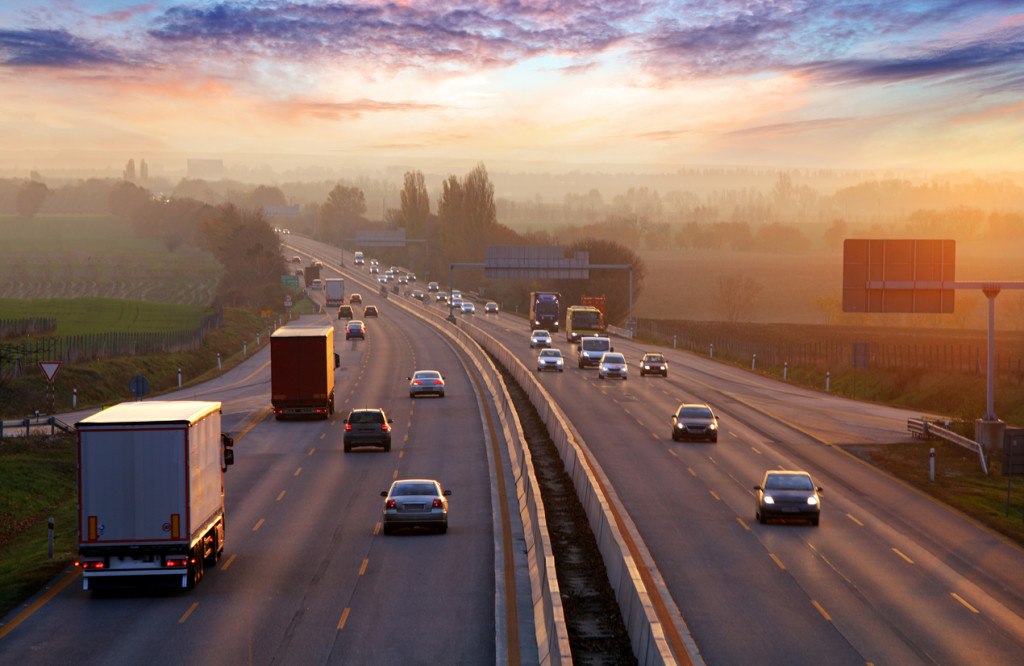 Befahrene Autobahn bei Sonnenuntergang