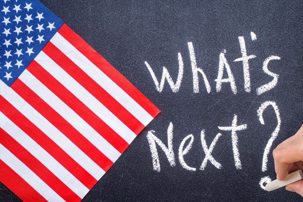 Amerikaflagge und Schriftzug "What's next?" auf Kreidetafel geschrieben