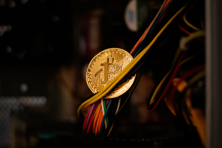 Bitcoinmünze zwischen Kabeln